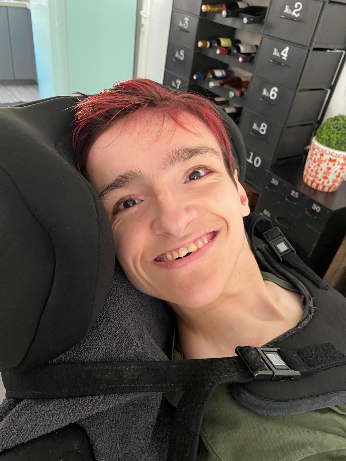 Anna souriante, installée dans son fauteuil.